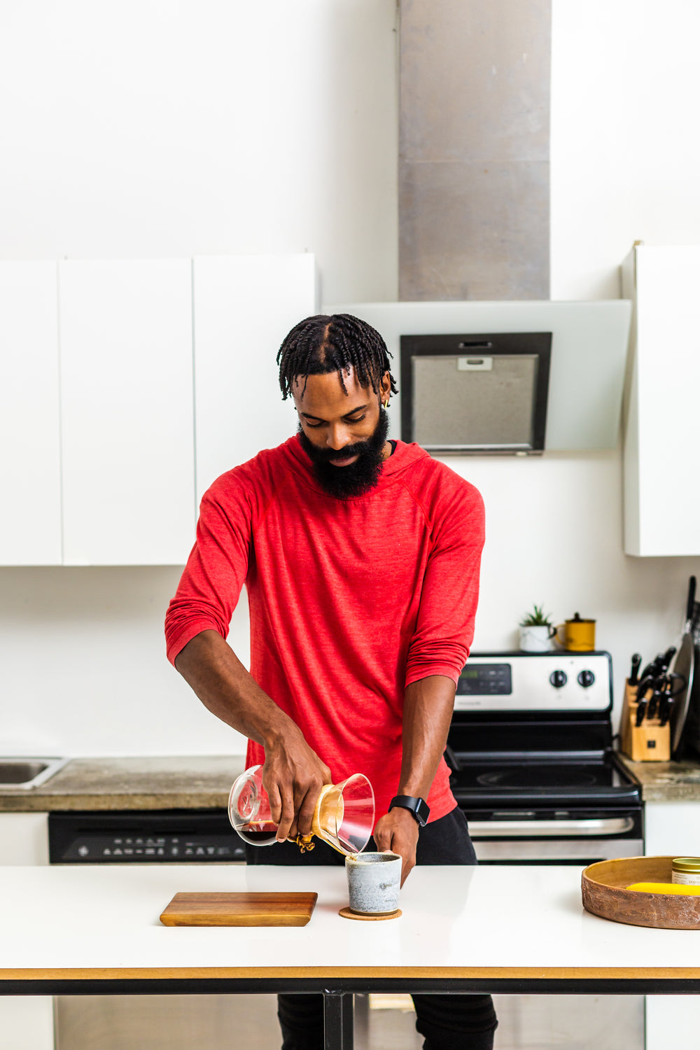 man in red makes pour over coffee