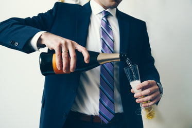 man in suit celebrates with champagne