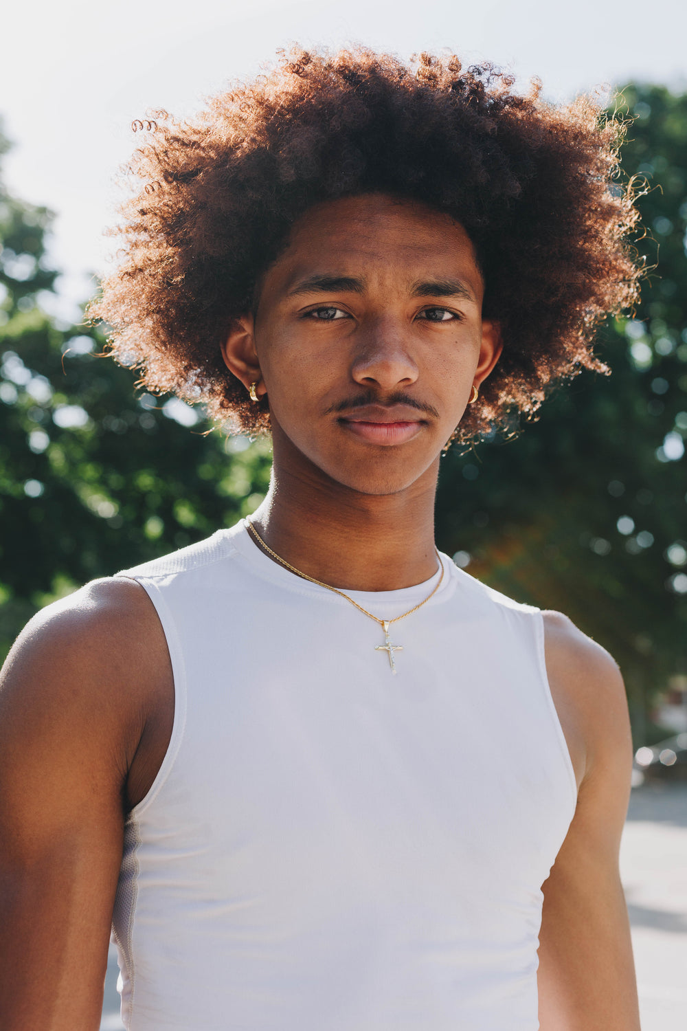 man in white tank top stands for camera