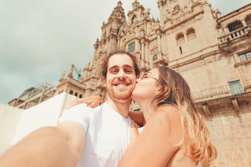 man kissed on the cheek while taking a selfie