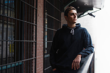 man leans on railing in fall fashion