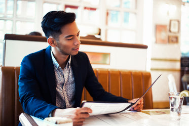 man looks at menu in restaurant