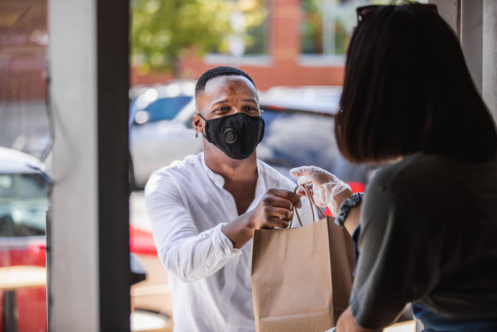 man picks up his order from a local shop