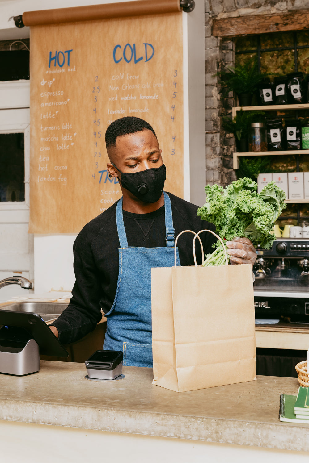 man places groceries into a paper bag