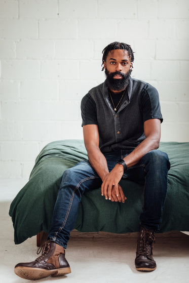 man poses in style at edge of bed