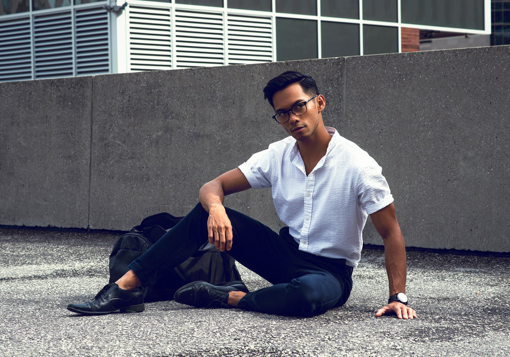 man poses on city rooftop