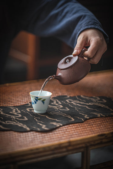 man pouring water into the cup