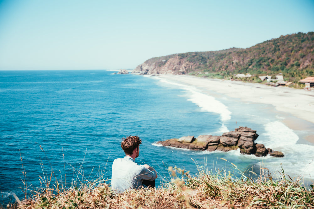 man reflecting by ocean