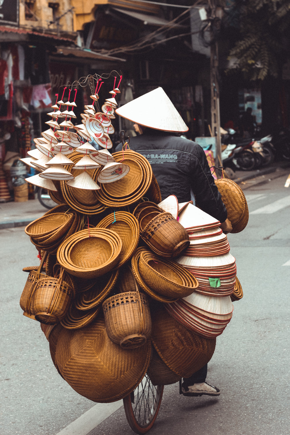 man riding bicycle with bowls and baskets