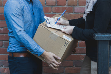 man signing for shipping box