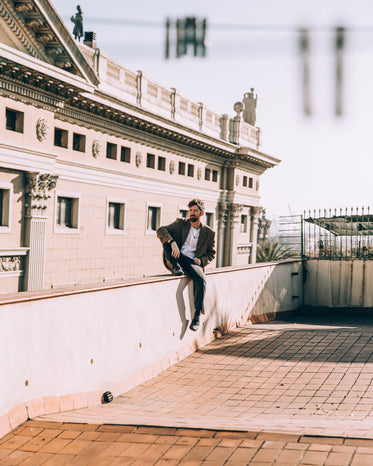 man sit casually on roof ledge