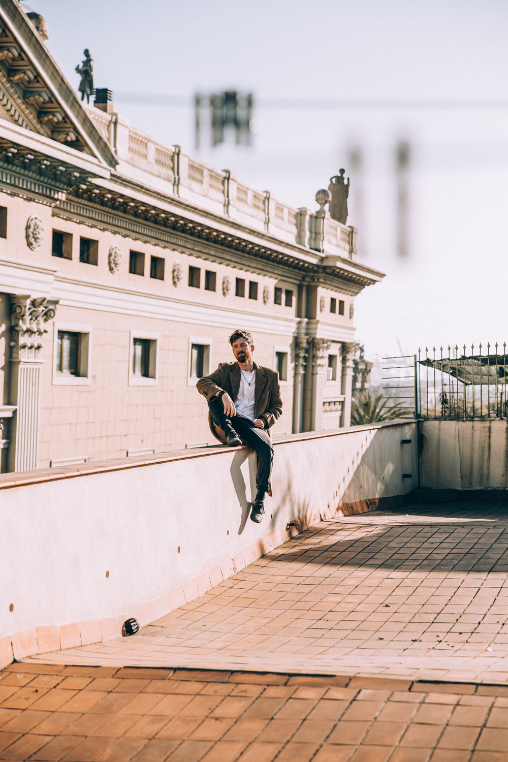 man sits casually on roof ledge