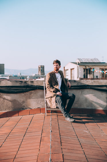 man sits on chair on roof