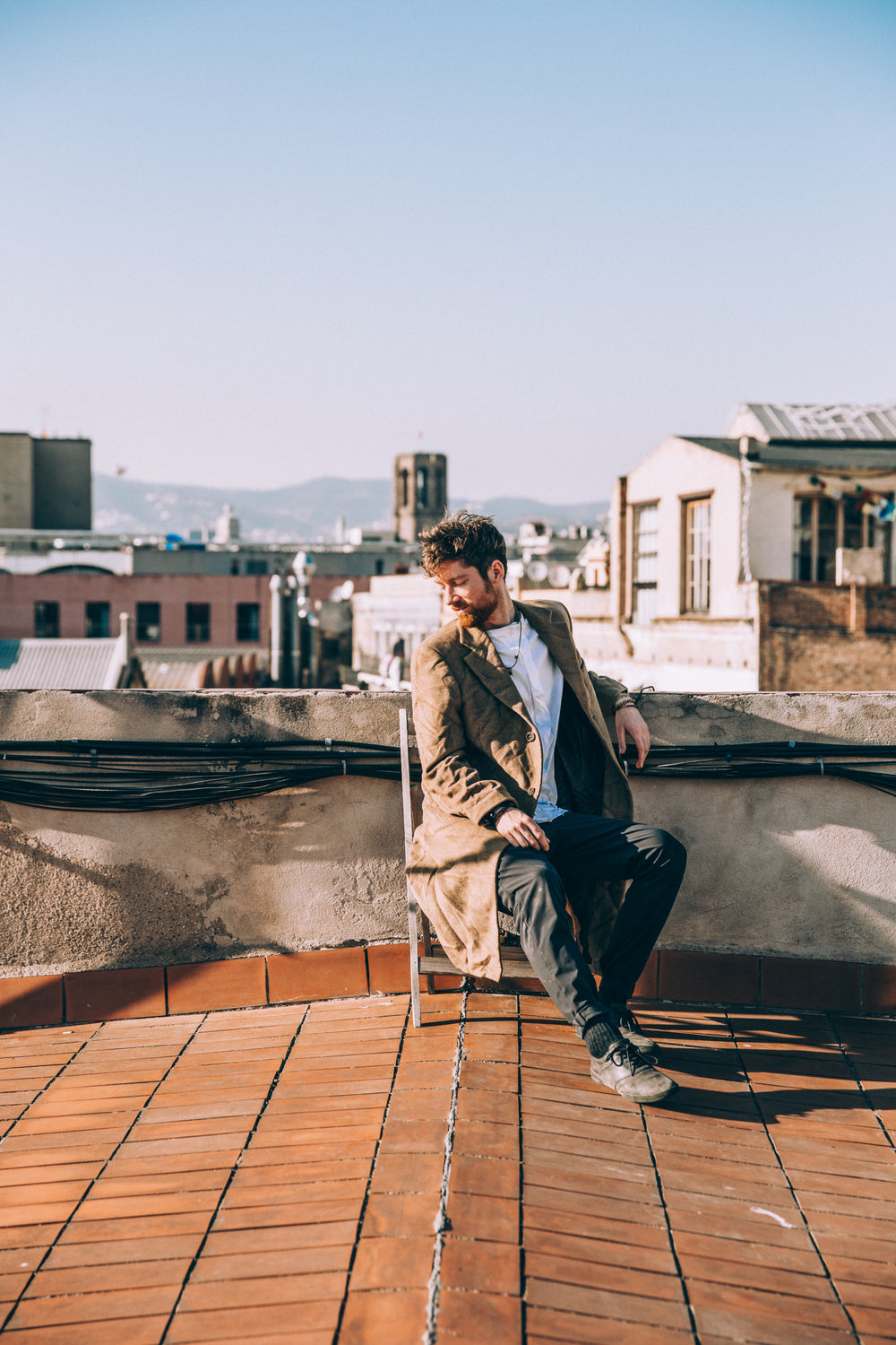 man sits on chair on rooftop