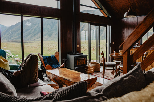 man sits on couch in mountain cabin