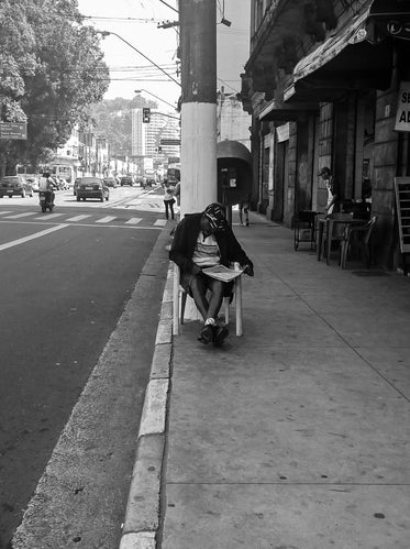 man sits streetside