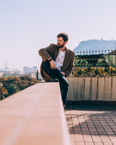 man sitting comfortably on roof ledge