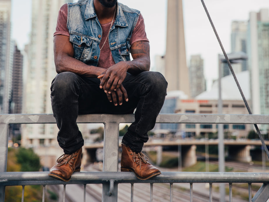 мужчина в стиле гранж сидит на ступеньках