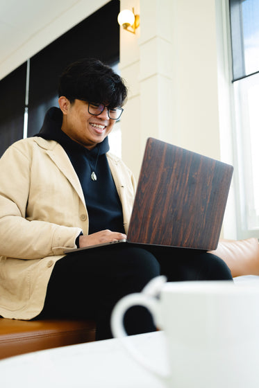 man smiles and looks at laptop screen