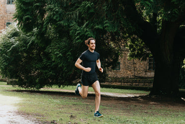 man smiles while out on a run in nature