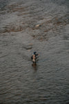 man standing in the river with a fishing rod