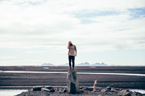 man standing on tall rock