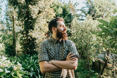 man surrounded by tall green trees