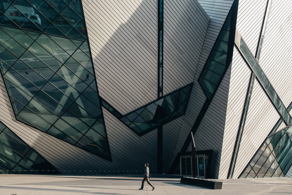 man walking in front of modern building