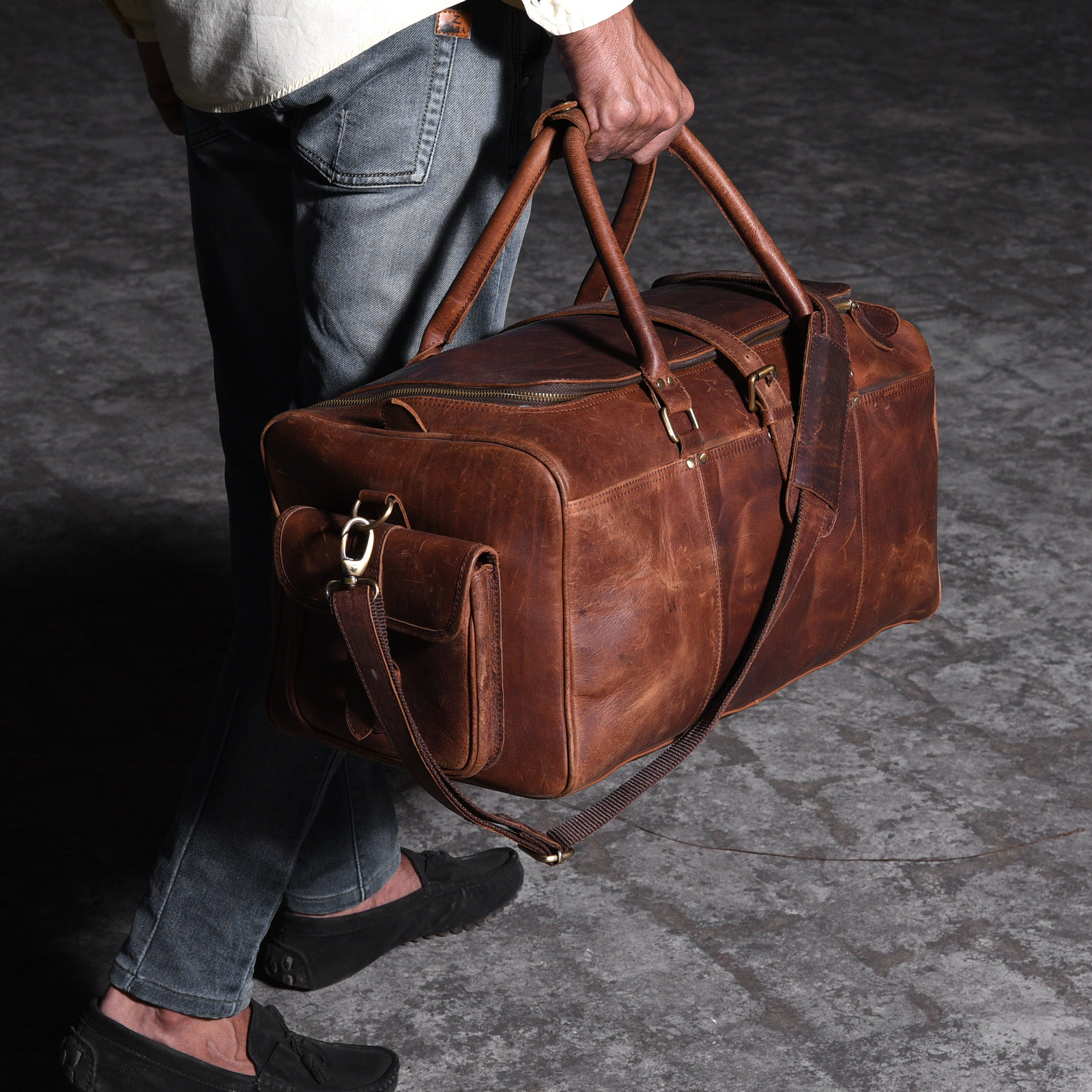 Man walking with a leather weekender bag through the city