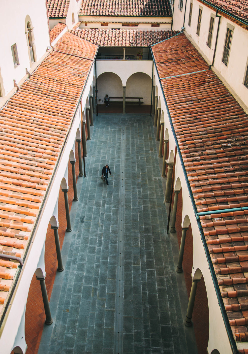 man walks through narrow courtyard