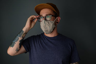 man wearing mask adjusting his glasses