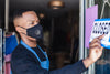 man wearing mask turns open sign