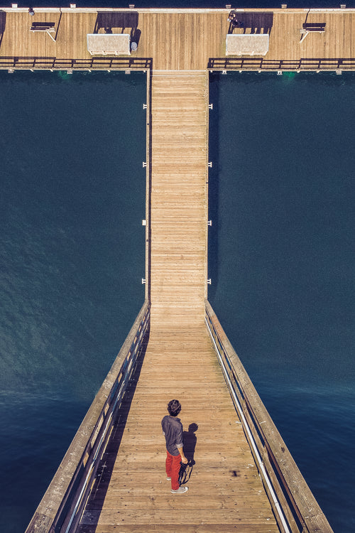 man with camera stood on a dock