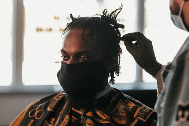 man with face mask in barbershop