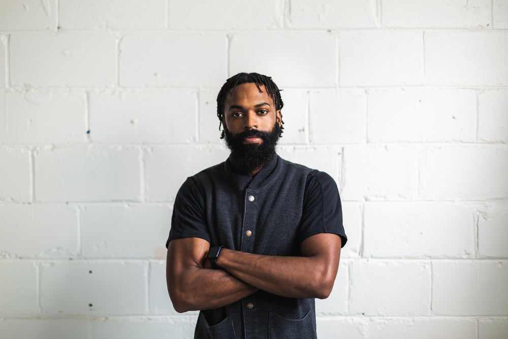 man with folded arms poses for camera