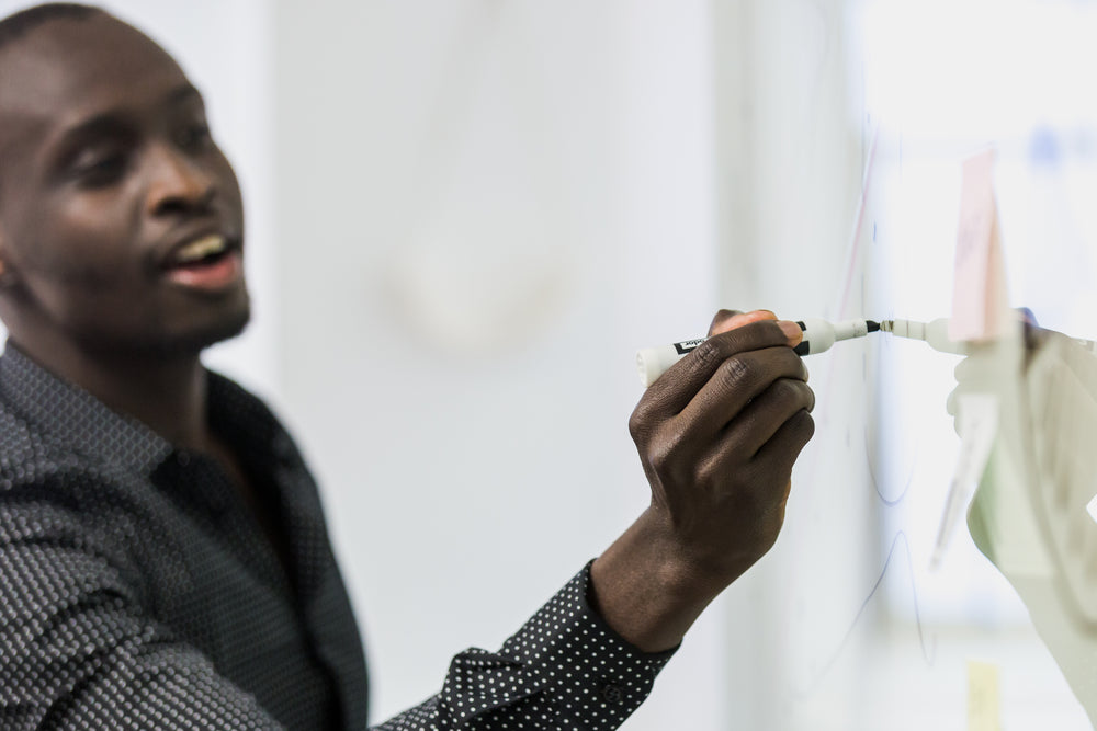 man writes on whiteboard