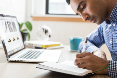 man writing in notebook