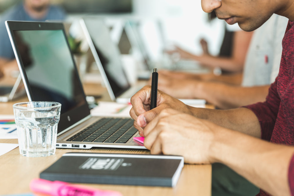 man writing in postit notes at meeting