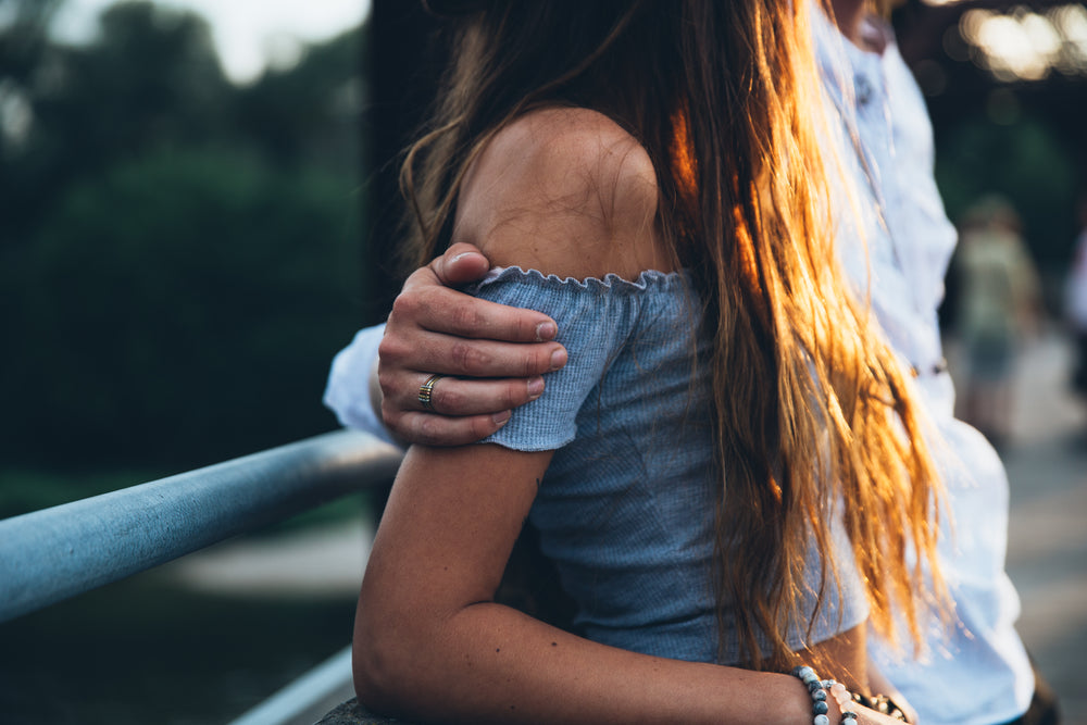 man's arm around woman