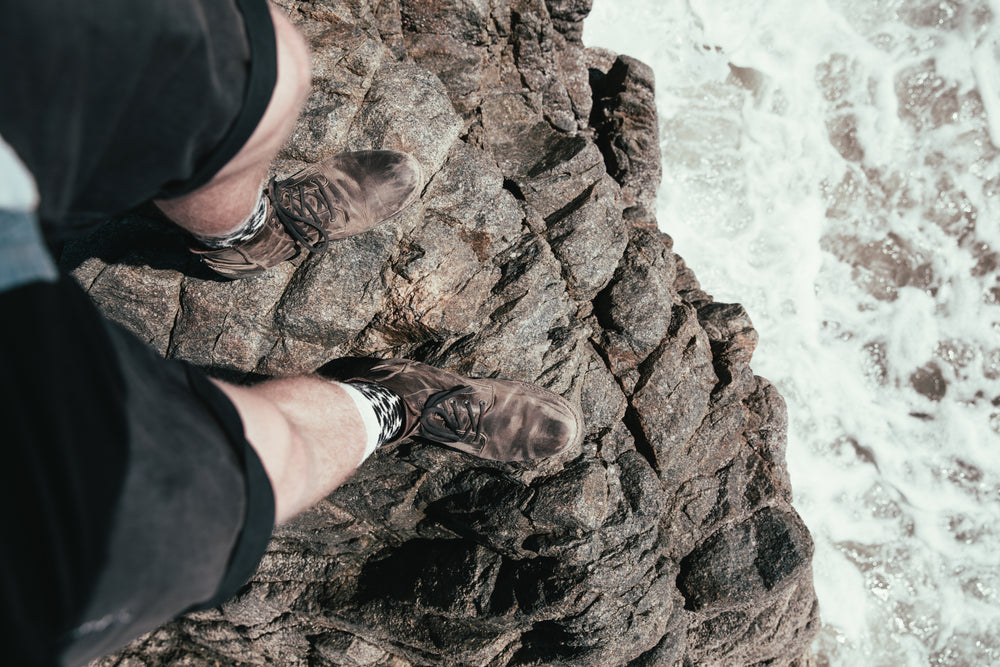 mans legs over cliff ledge