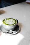 matcha latte in a grey mug on a white table