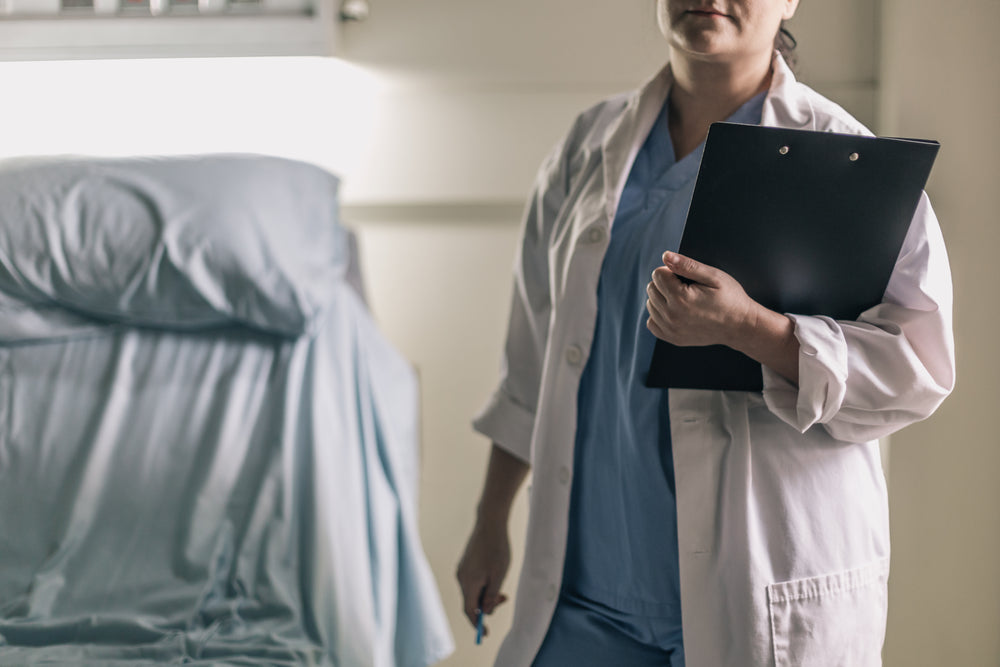 medical professional in scrubs holding clipboard and pen