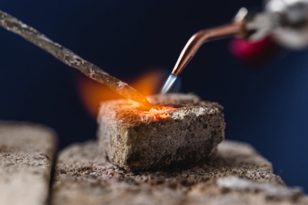 butane torch melting metal onto a stone block — durable wedding bands for construction workers and mechanics