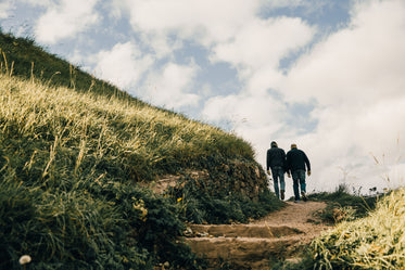 men hiking grassy hills