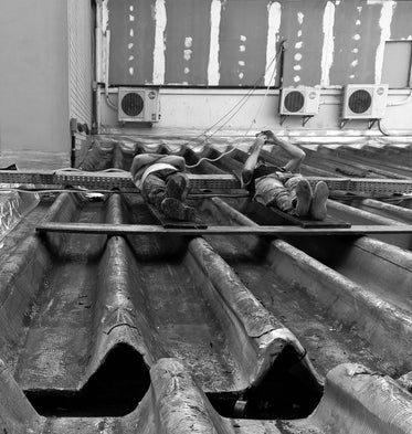 men laying on metal rooftop