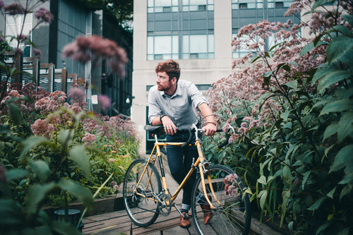 men's fashion man with bicycle surrounded by flowers