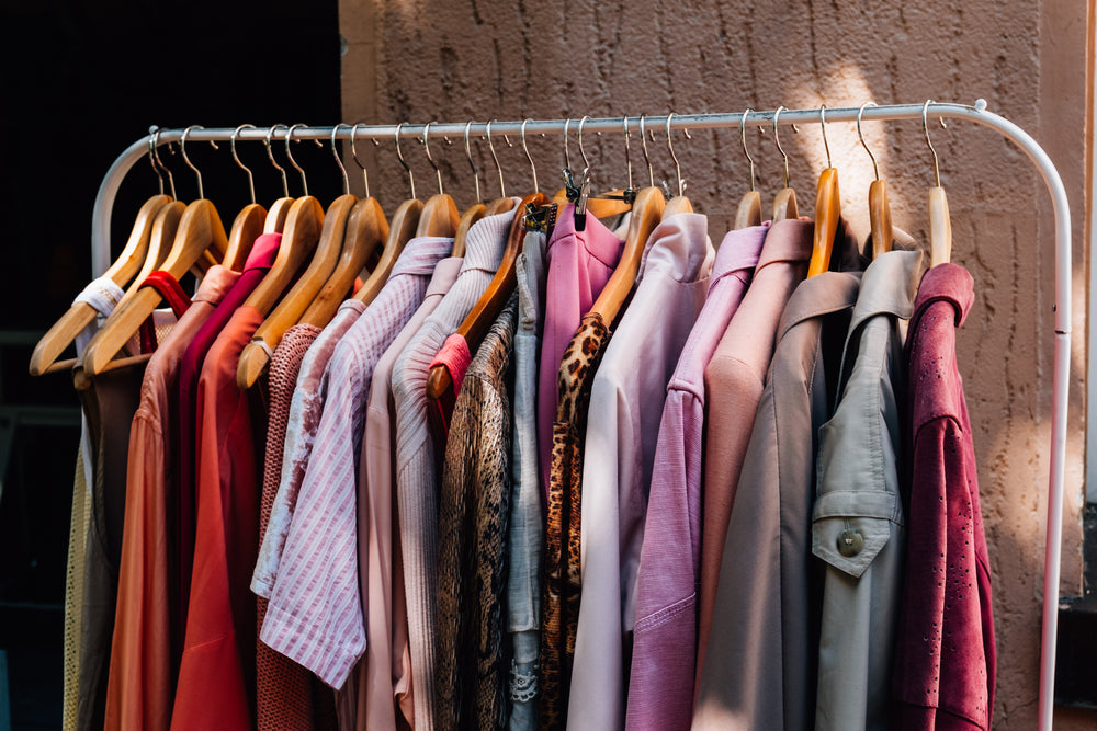 metal clothing rack with warm colored clothing