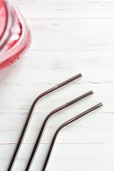 metal drinking straws on wood