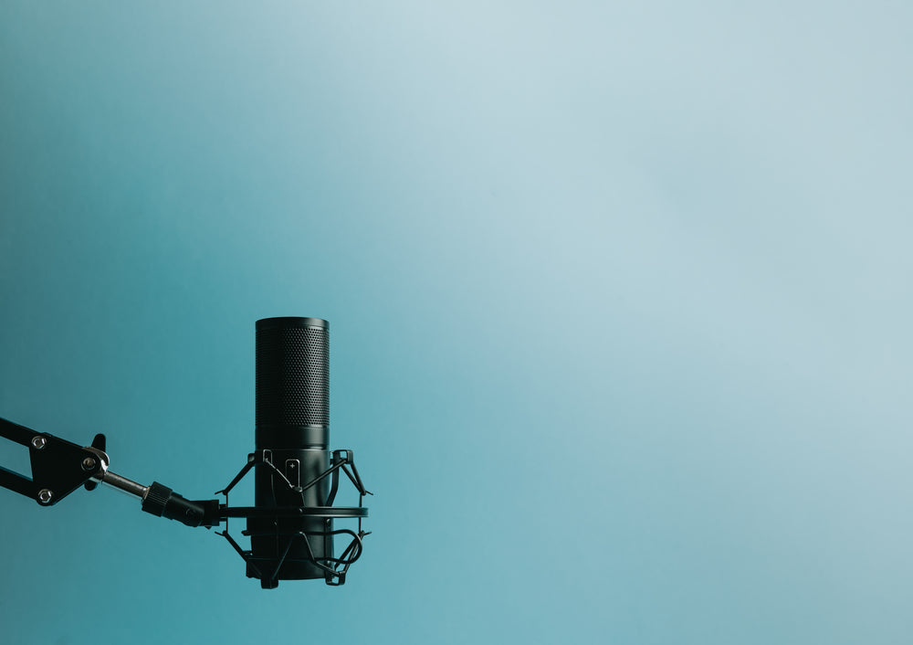 microphone on stand left of frame against blue