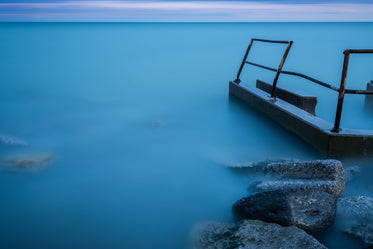 mist rolling over water by some rocks